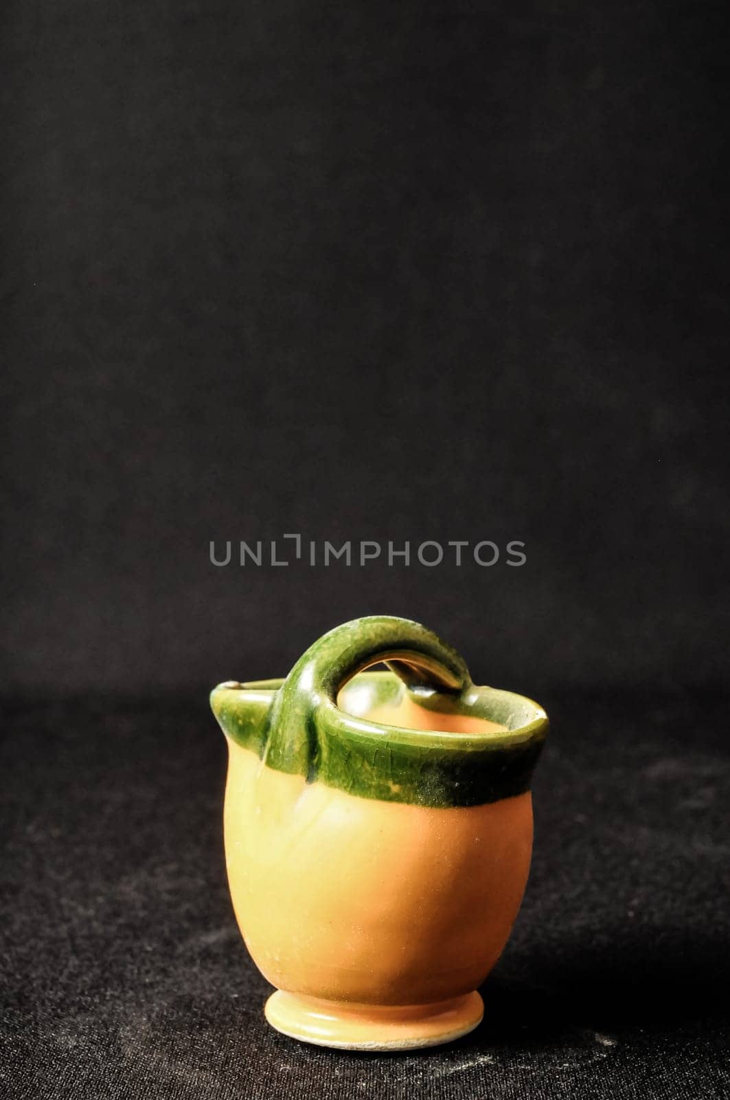 Colorful designed clay vase over a Black background