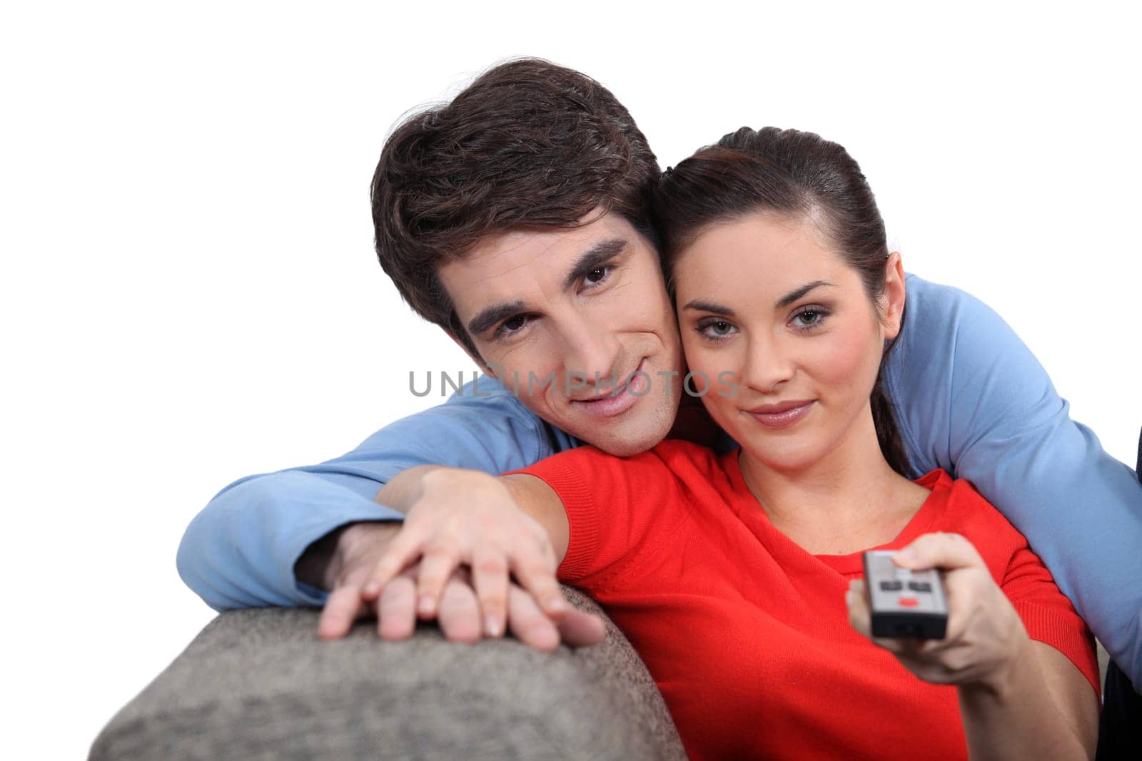 Couple sitting on a sofa with a remote control