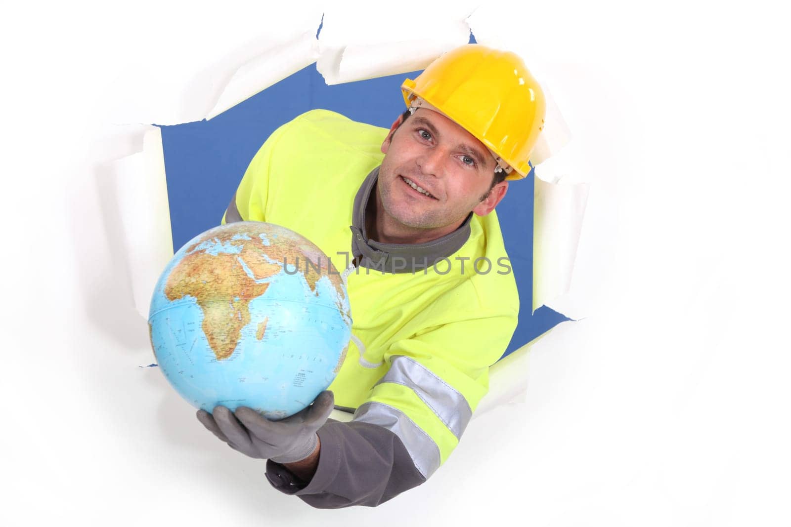 craftsman breaking a paper wall and holding a globe