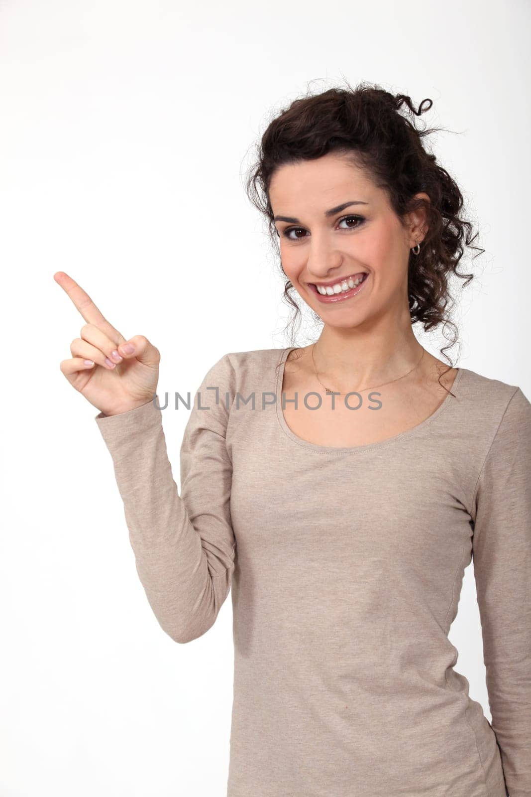 portrait of cute young woman all smiles pointing sideways