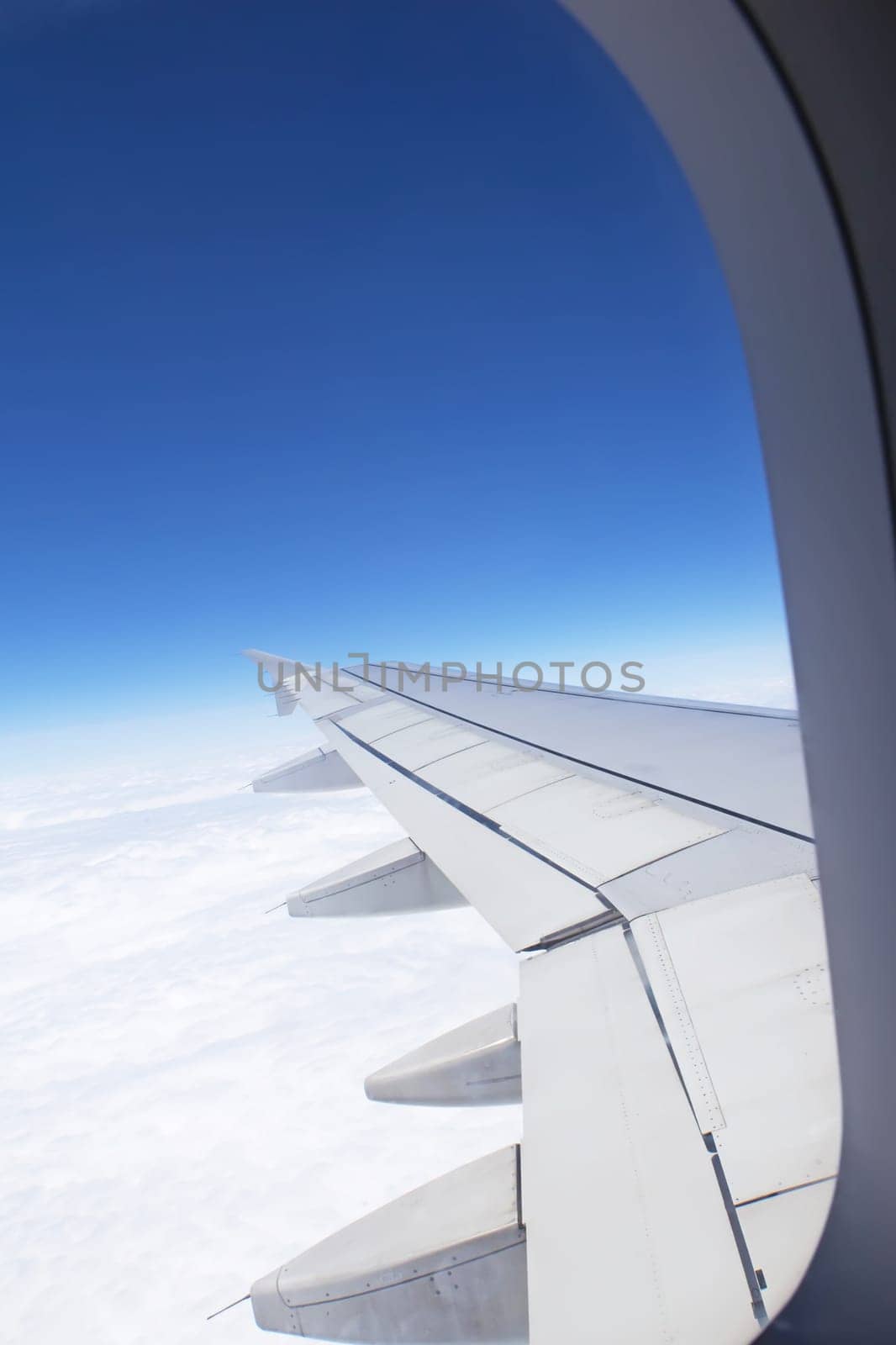 Airplane window looking out over the wing. Vertically.
