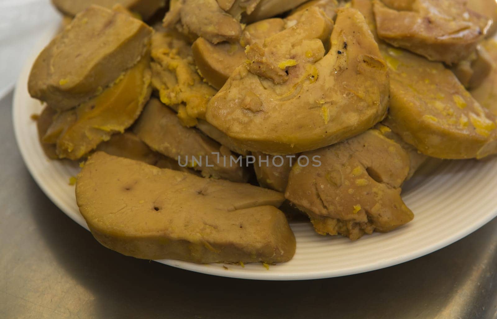 Pieces of raw duck foie gras on a porcelain plate