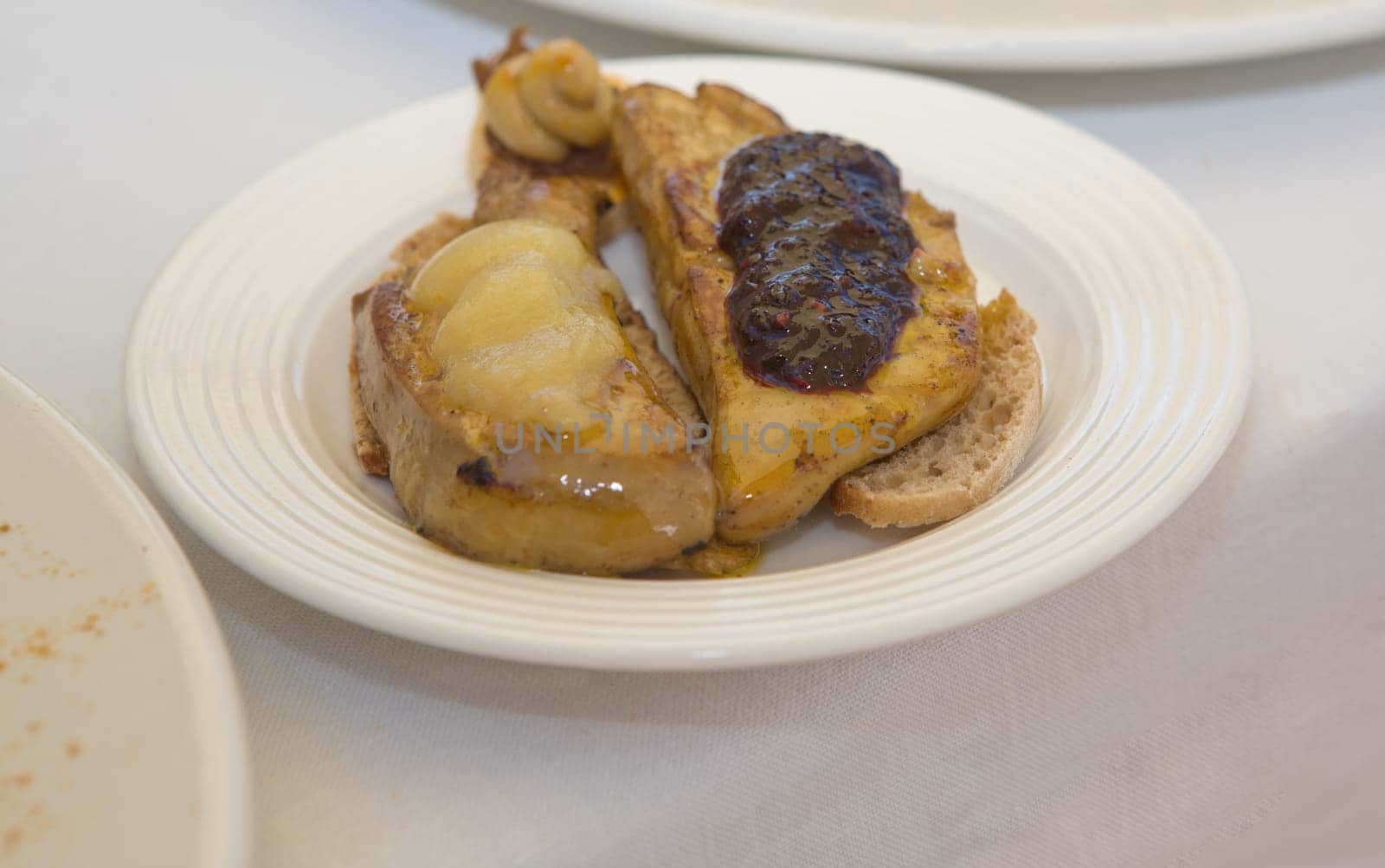 Placing the hot grilled foie gras over bread slices