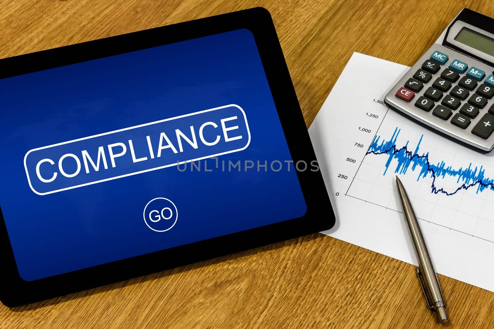 compliance word on digital tablet with calculator and financial graph