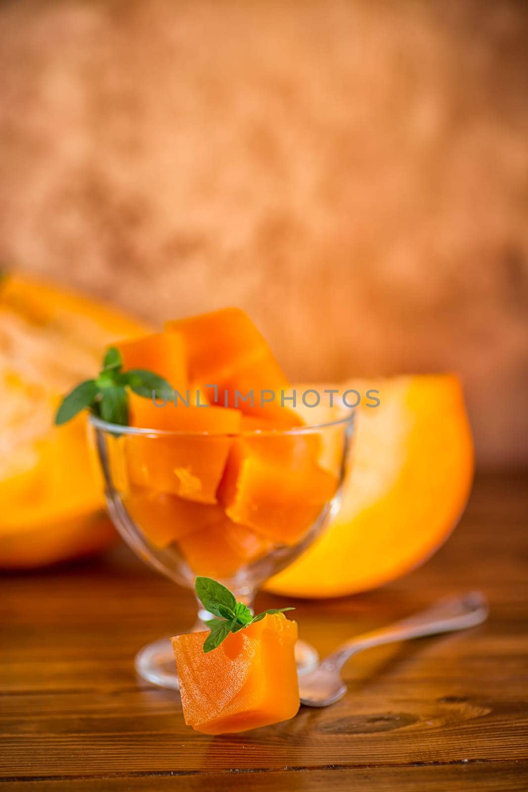 Prepared sweet pumpkin marmalade in a glass bowl on a wooden table. Autumn recipes.