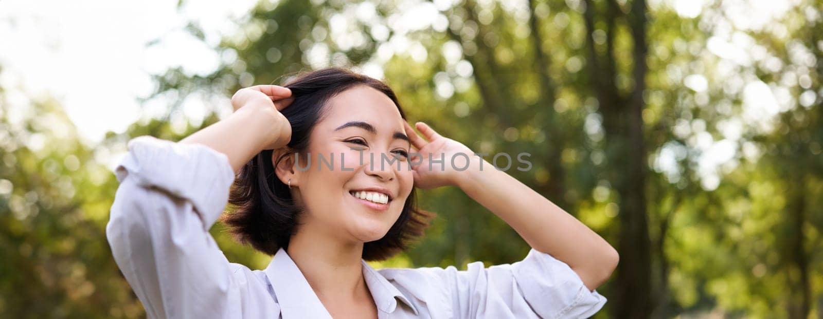 Genuine people. Portrait of asian woman laughing and smiling, walking in park, feeling joy and positivity.