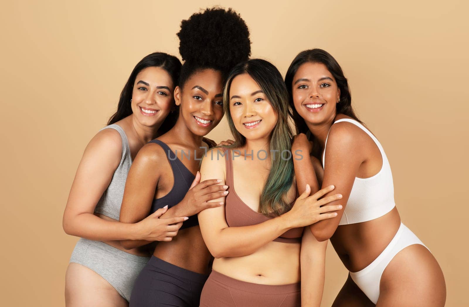 Four diverse women pose together, exuding confidence and natural beauty, standing wearing simple underwear, celebrating the essence of feminine diversity and elegance