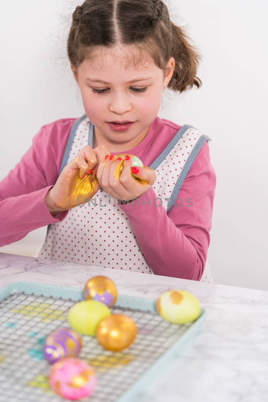 Easter egg coloring. Painting Easter eggs with gold luster.