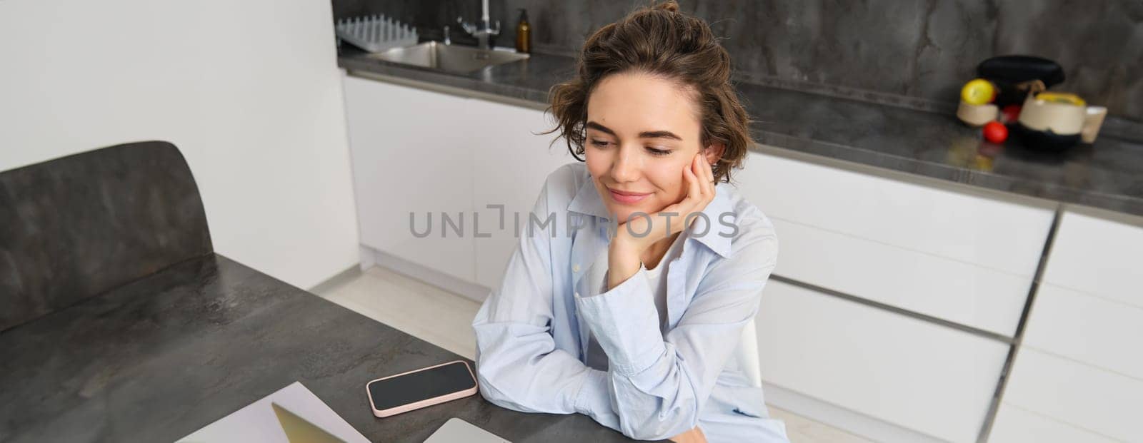 Portrait of young woman watching video on laptop computer, working from home, studying online, listening webinar course by Benzoix