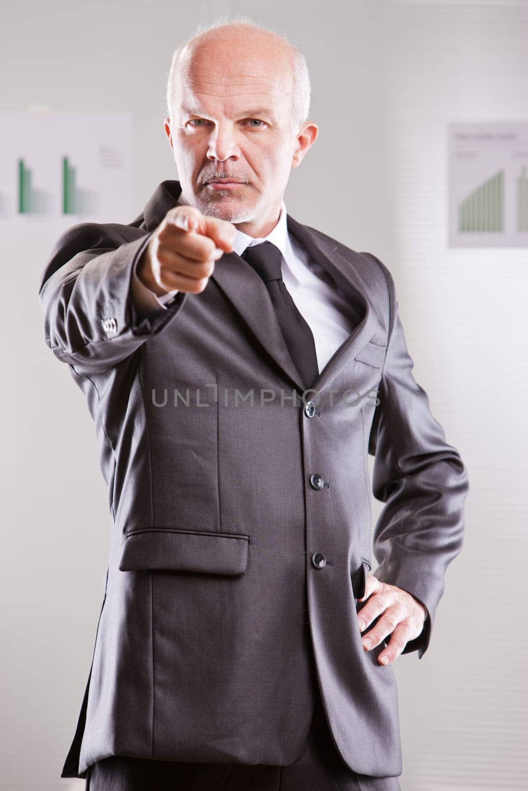 businessman pointing at you with an extremely serious expression