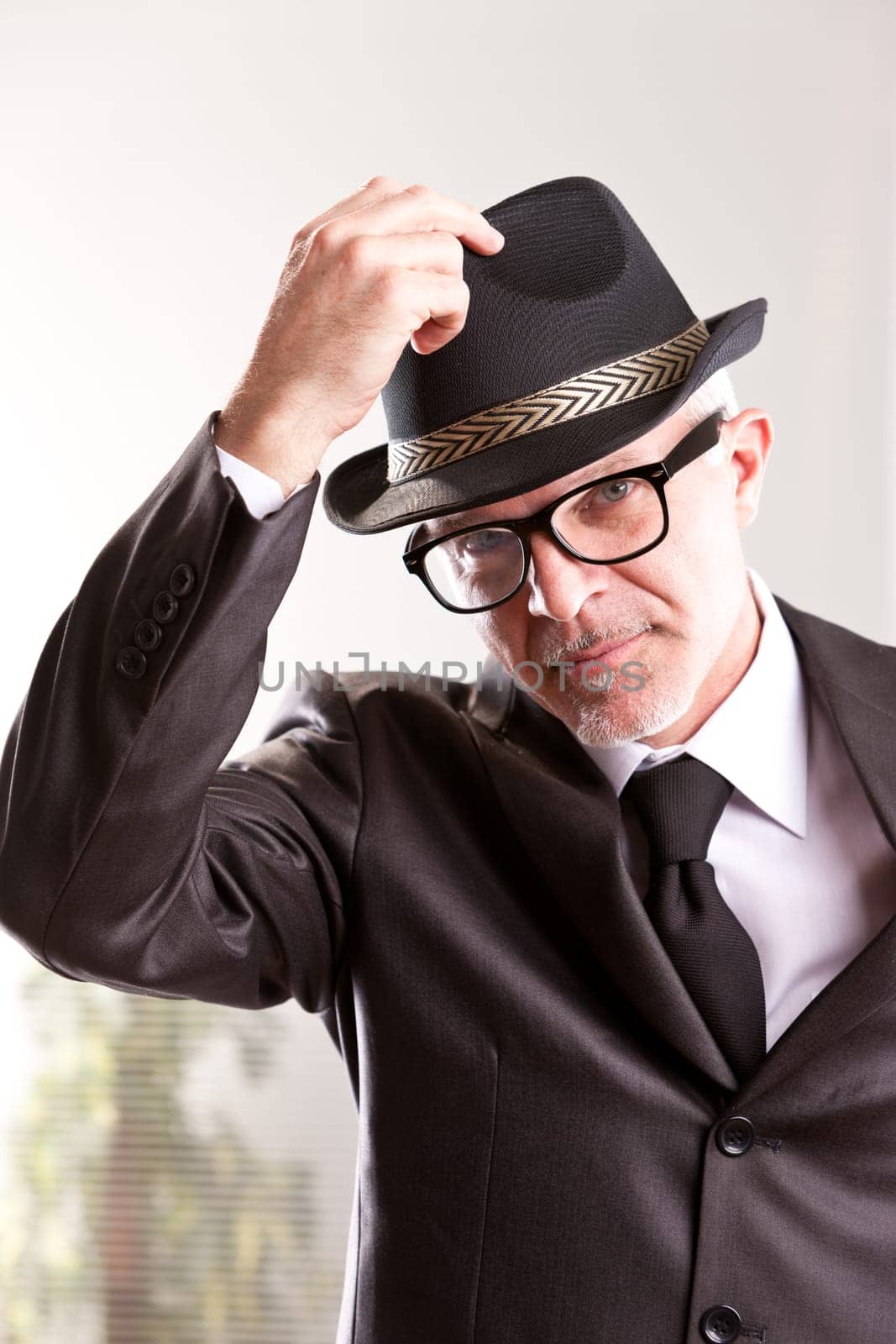 A fifties style retro businessman rising his hat to salute you