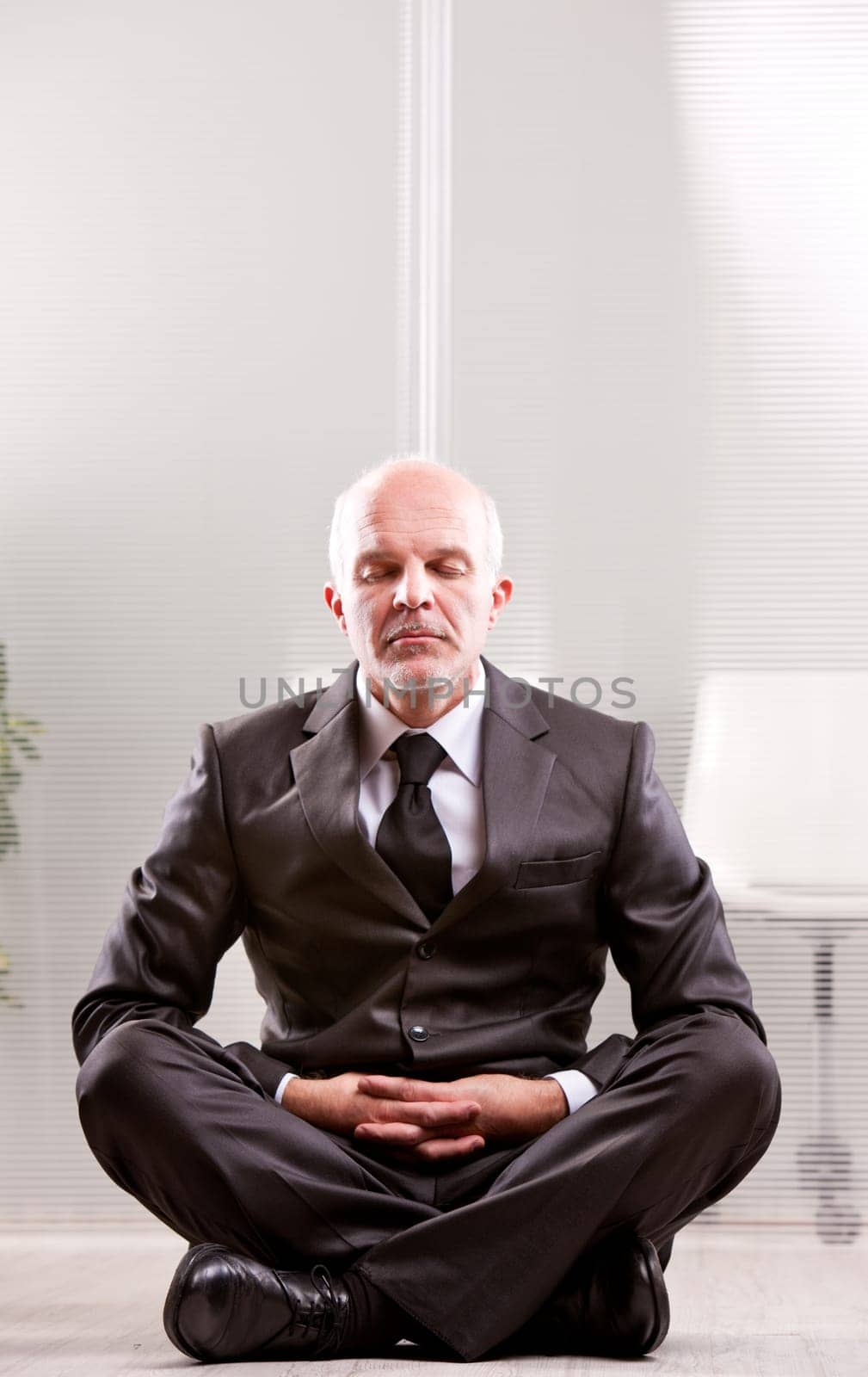 relaxed businessman meditating with the leg crossed
