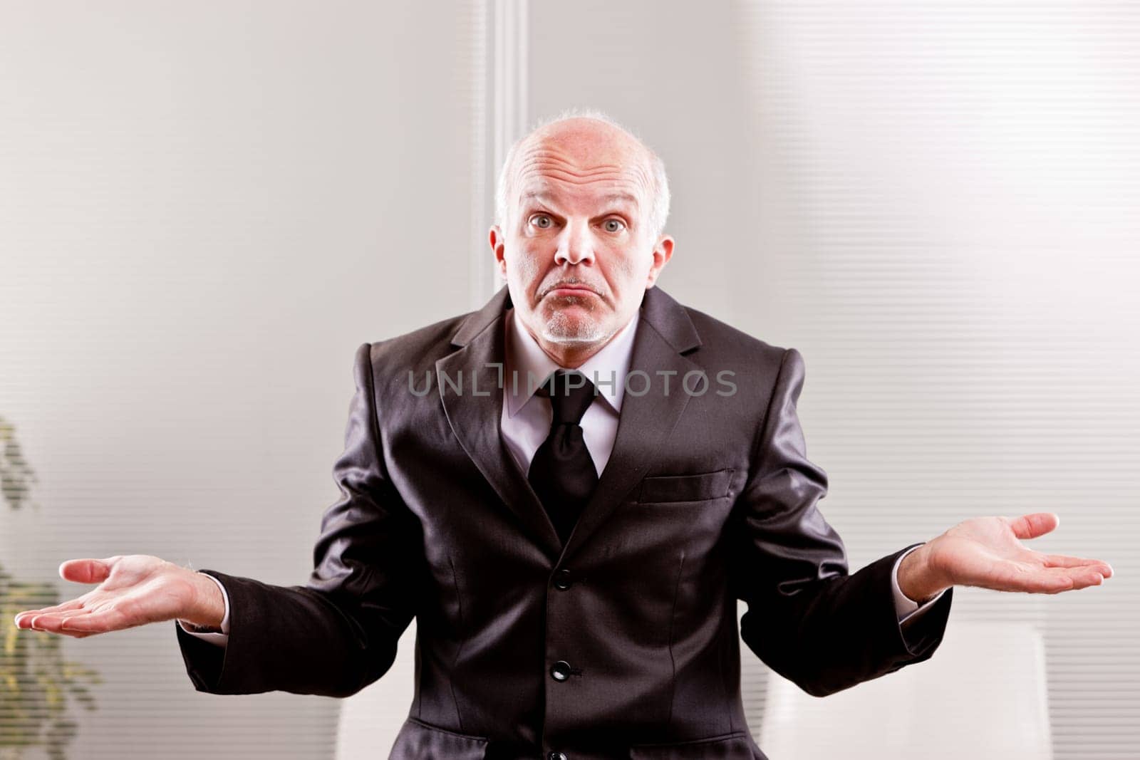 feeble businessman expressing impotence with a typical italian gesture