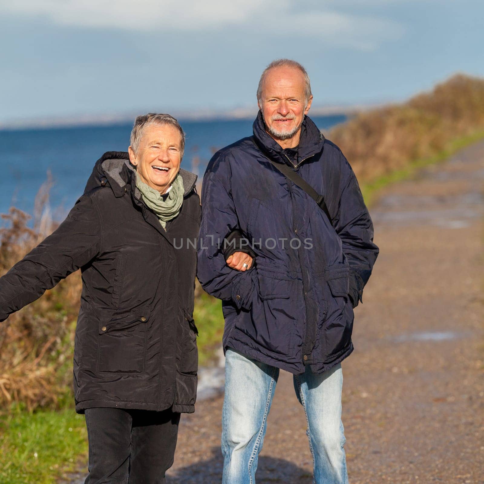 older happy couple makes a beach walk in autumn baltic sea landscape sea