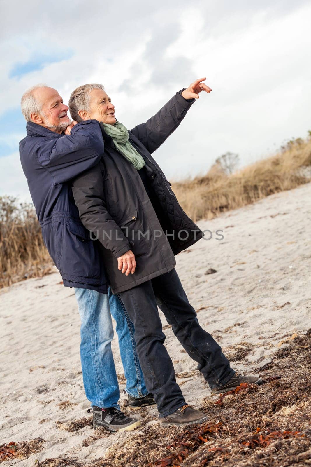 older adult happy couple walks on the beach in autumn lifestyle happiness