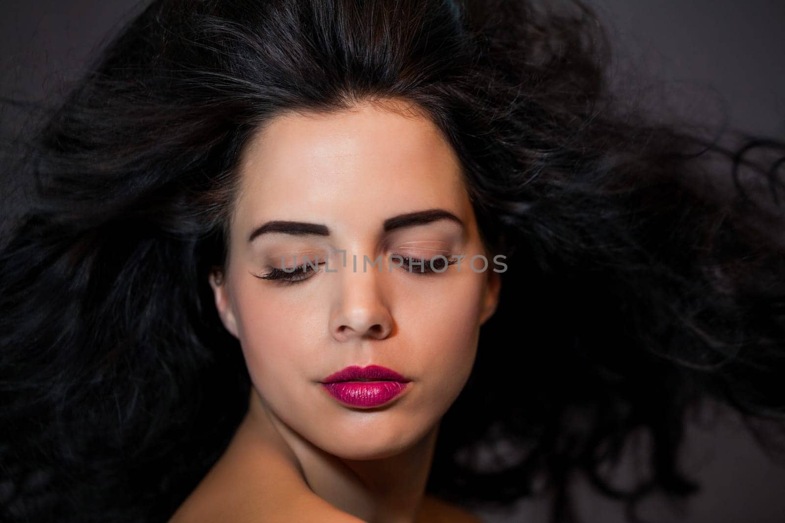 young attractive woman with red lips and dark curly hair with lots of volume portraitboy attractive woman with red lips and dark curly hair with lots of volume portrait
