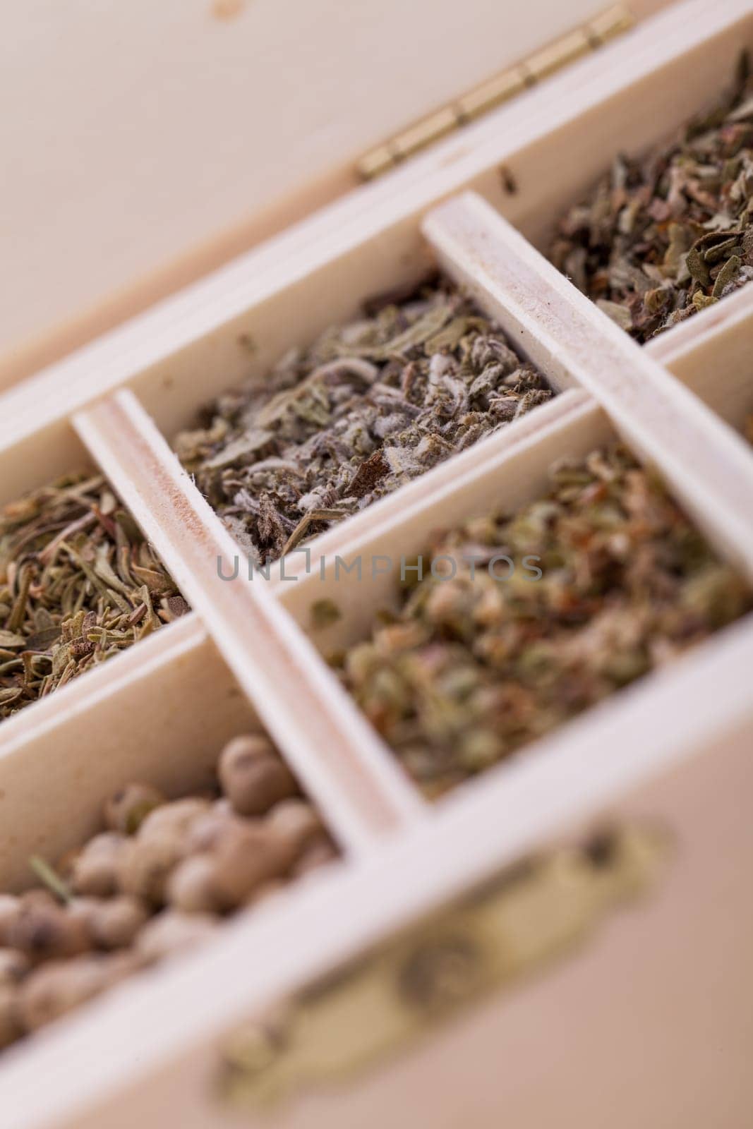 various dried herbs spices in a wooden box macro detail aufnahme