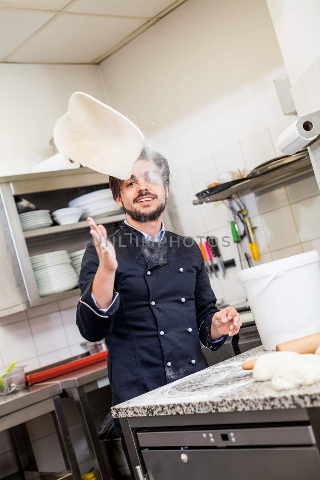 young chef throwing dough pizzadough pizza baker in the restaurant kitchen