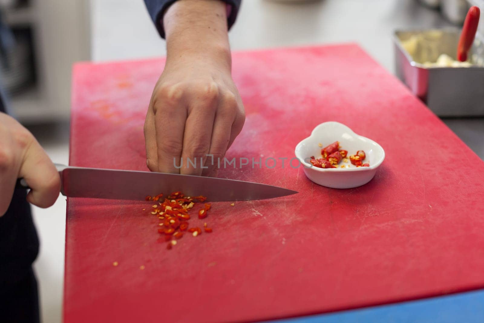 chef cuts fresh red chilli small in the restaurant kitchen to eat gatsronomie food