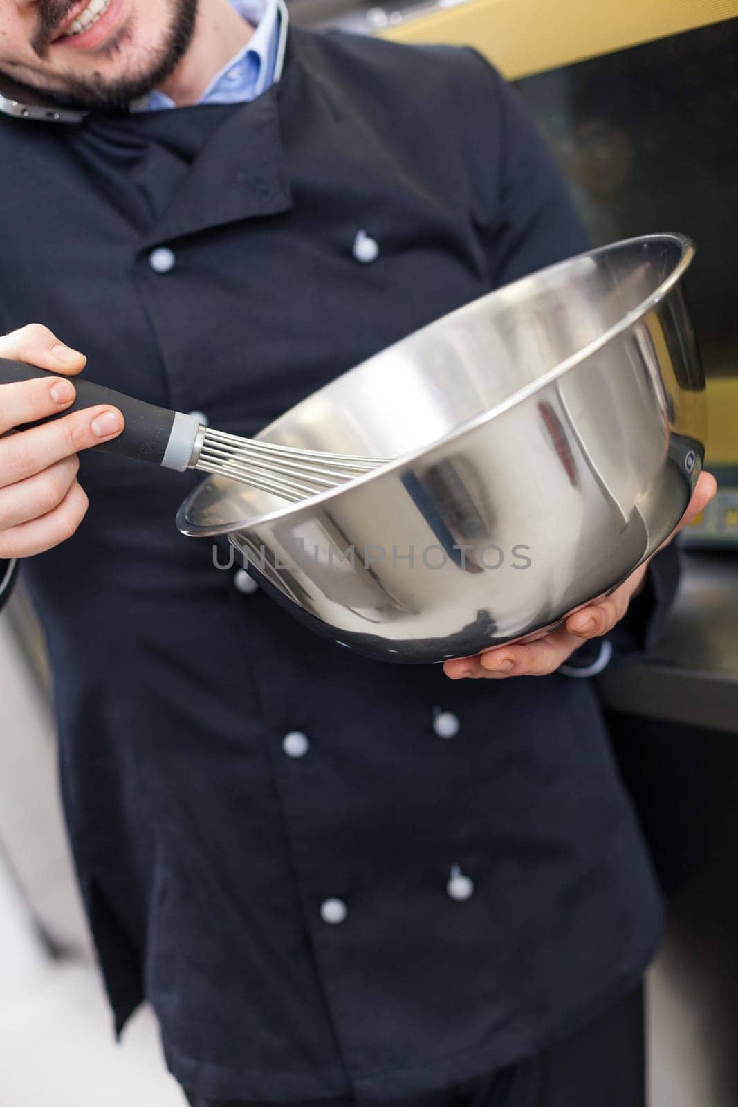 young adult chef in the restaurant kitchen while cooking at the herd preparation
