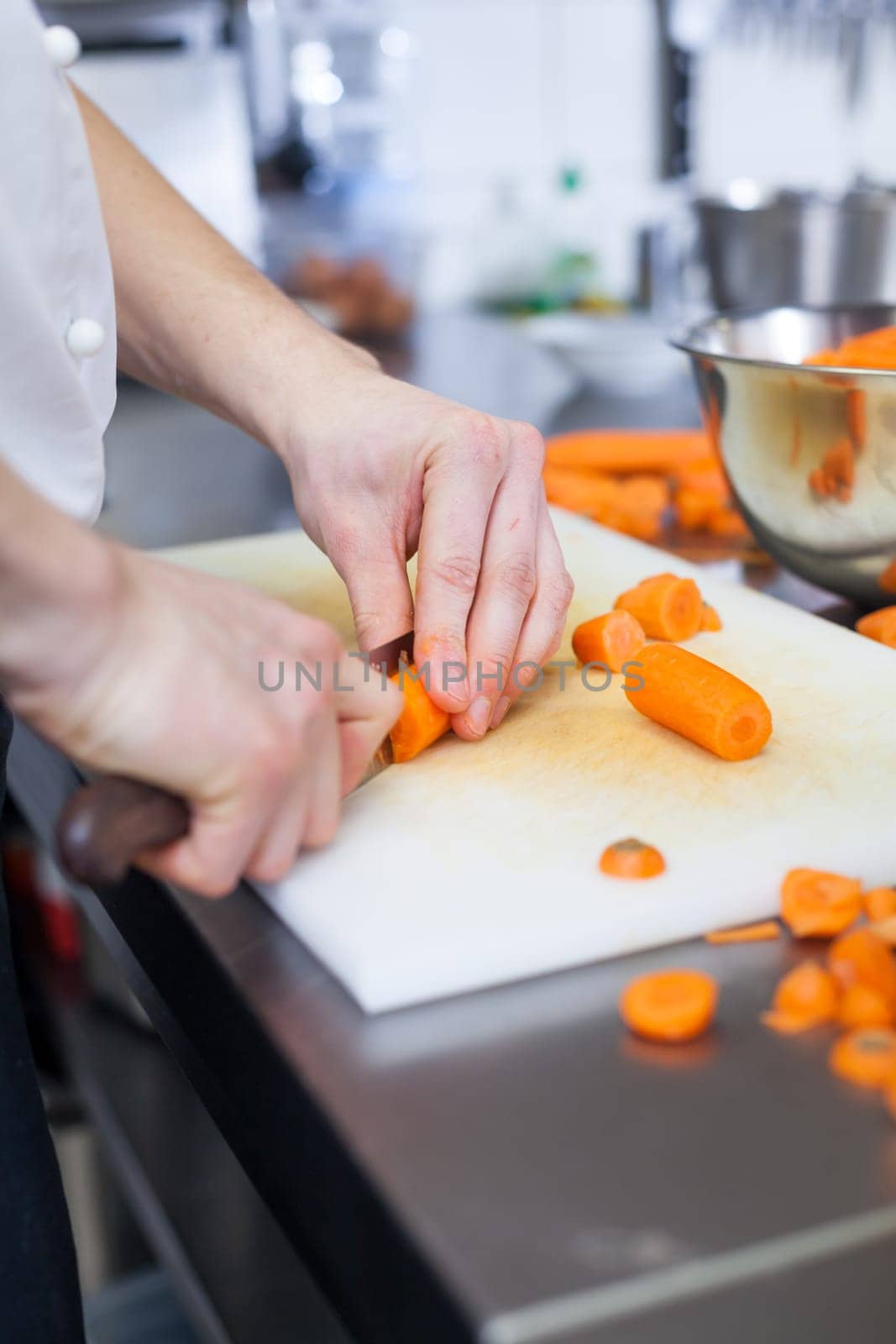 chef cuts fresh carrots in restaurant kitchen pre-beader ingredients eat food gastronomy work