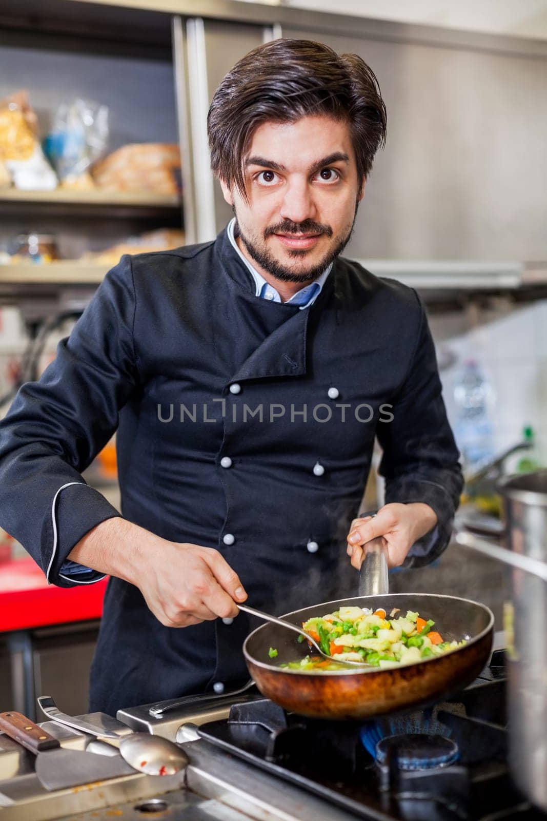 young adult chef in the restaurant kitchen while cooking at the herd preparation