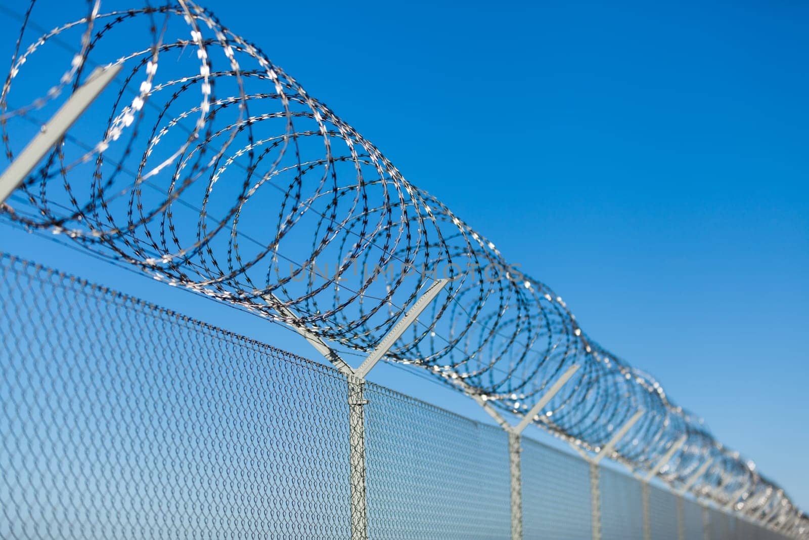 barbed wire fence outdoors in front of blue sky macro close-up detail