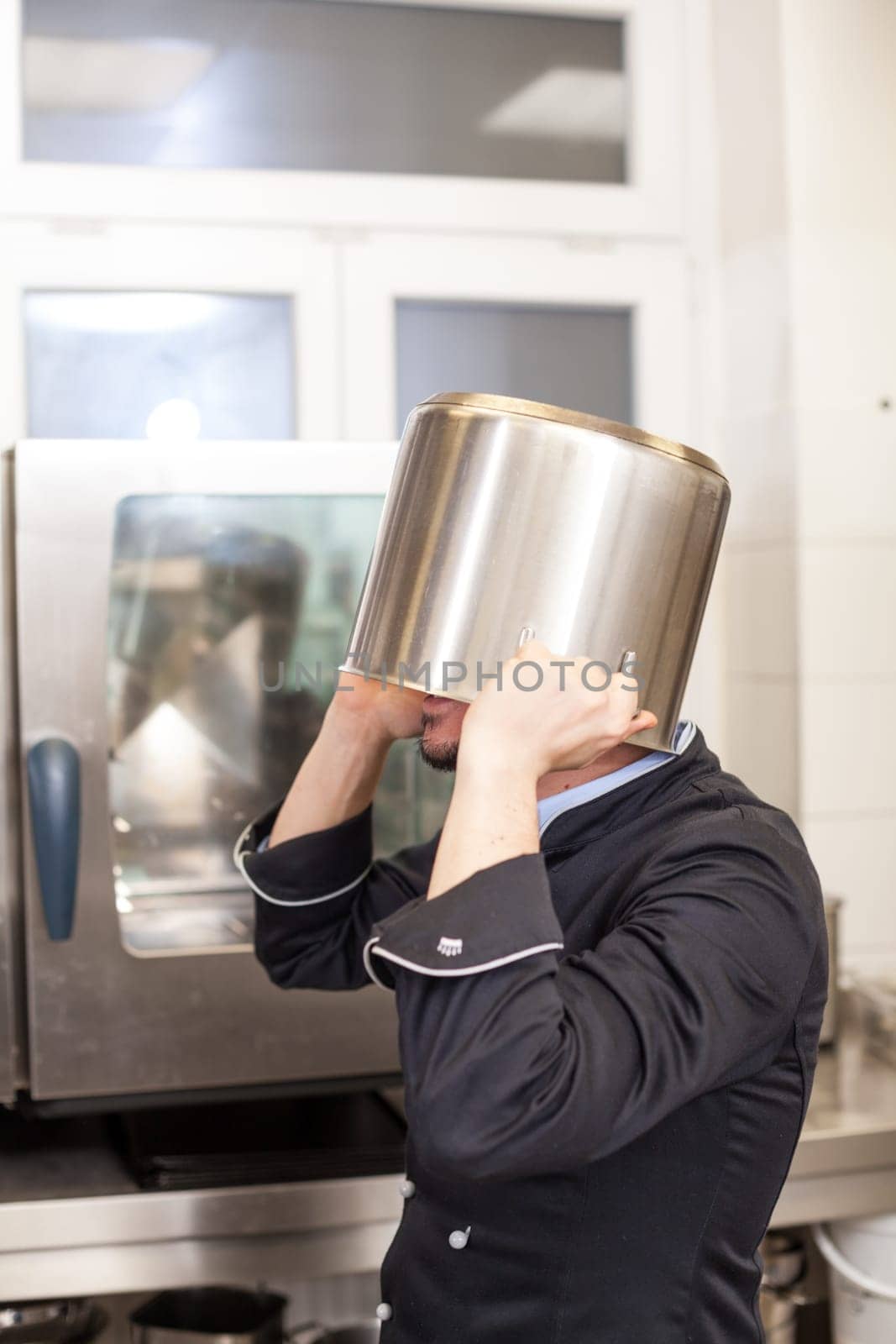 young adult chef in the restaurant kitchen while cooking at the herd preparation