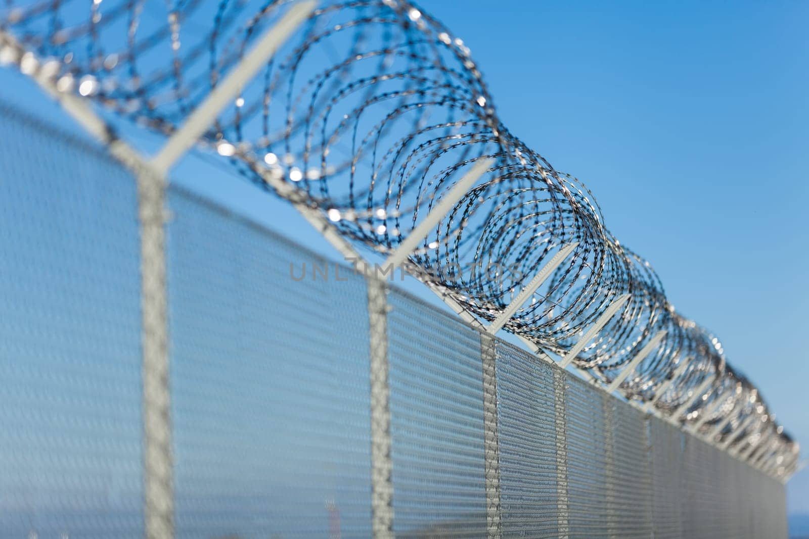 barbed wire fence outdoors in front of blue sky macro close-up detail