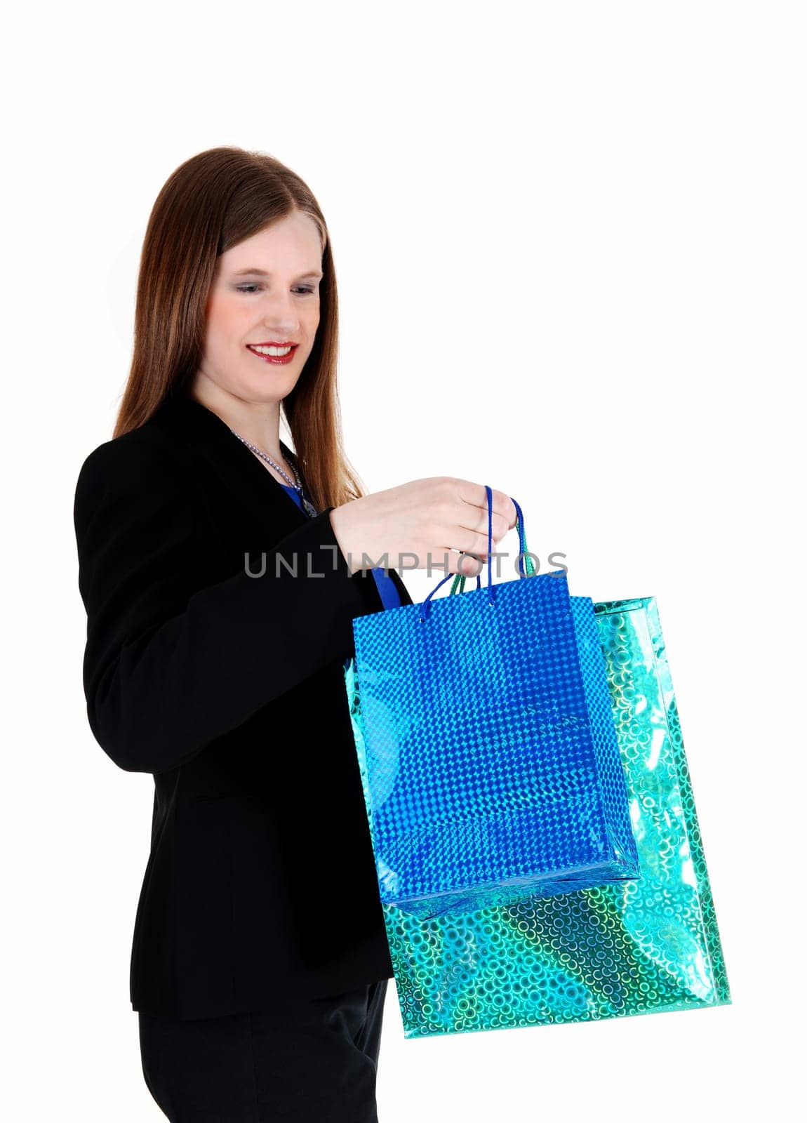 A young pretty woman in a black suit standing for white background.with some shopping bag's in her hand..
