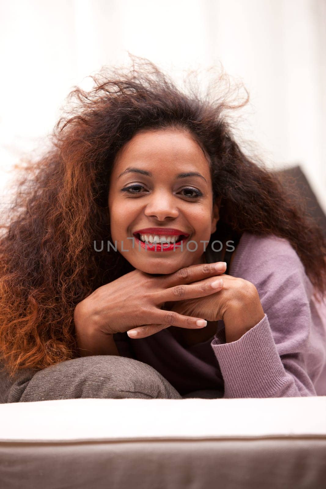beautiful young black happy woman on a sofa in her living room