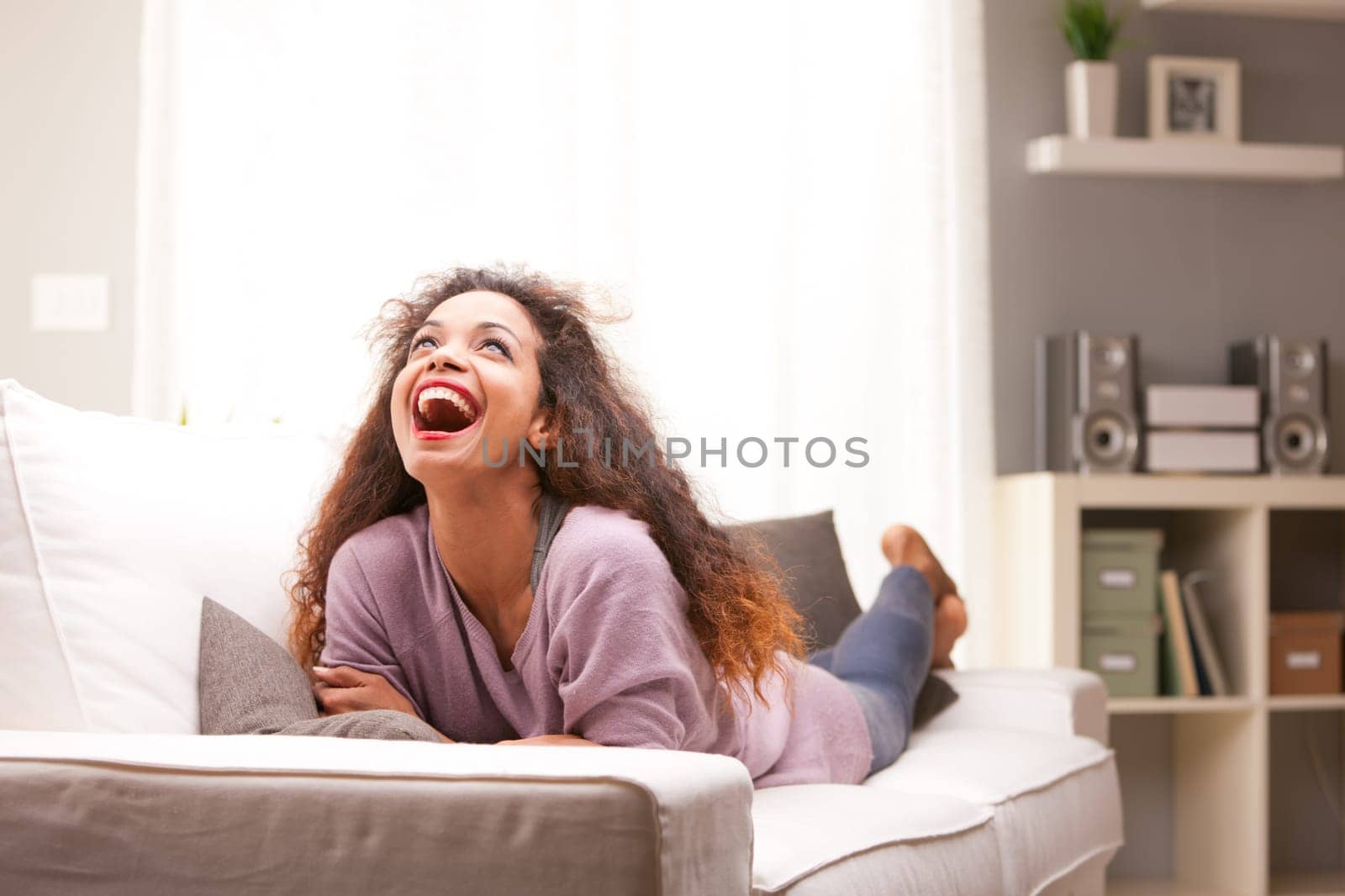 beautiful young black happy woman on a sofa in her living room