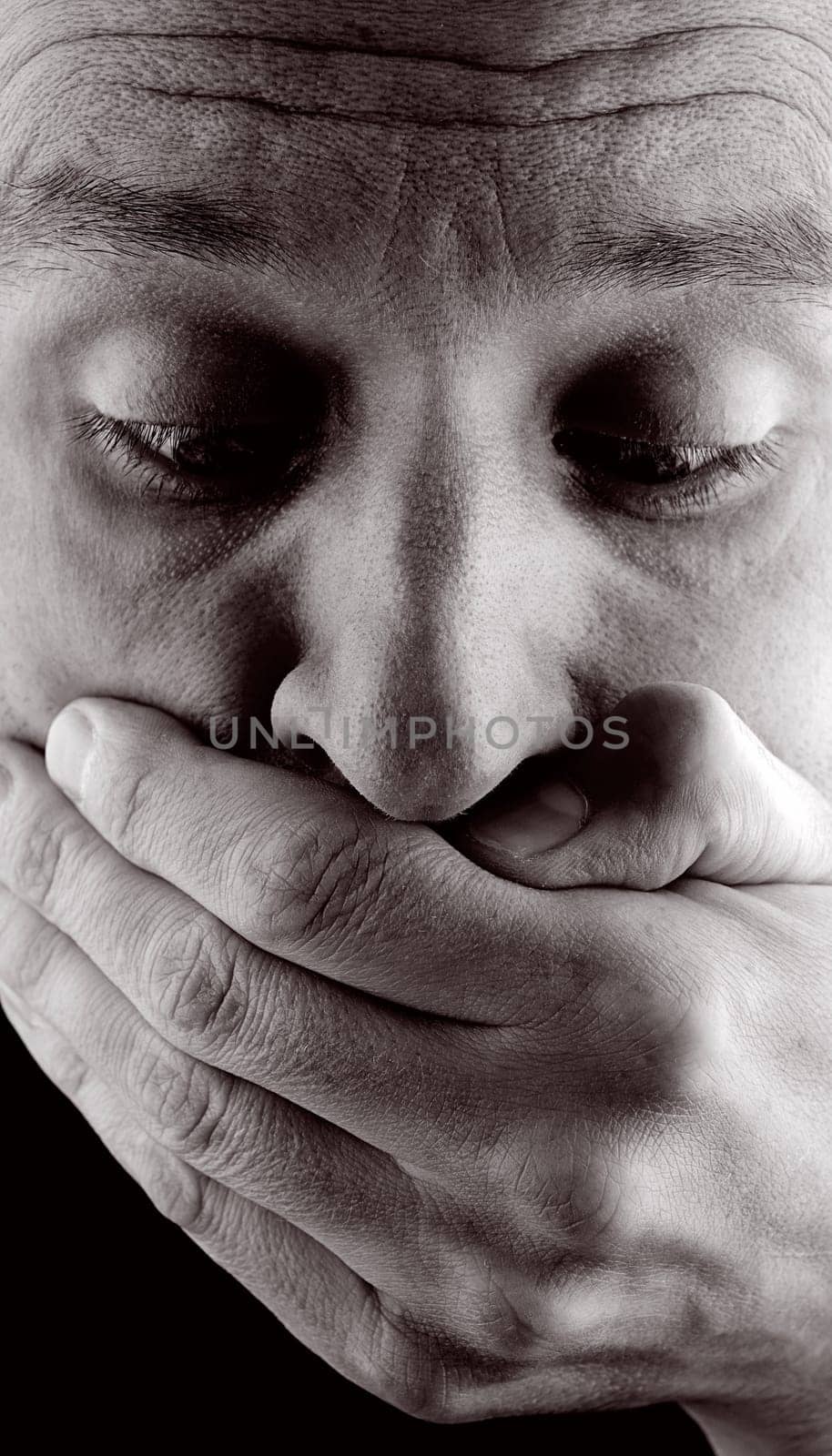 Man holds his hand in front of his face
