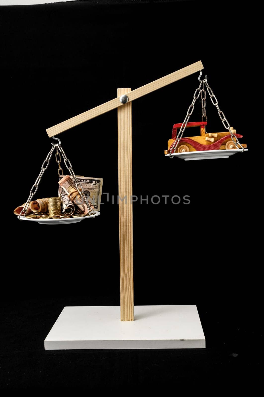 Money and Toy Wooden Car on a Two Pan Balance