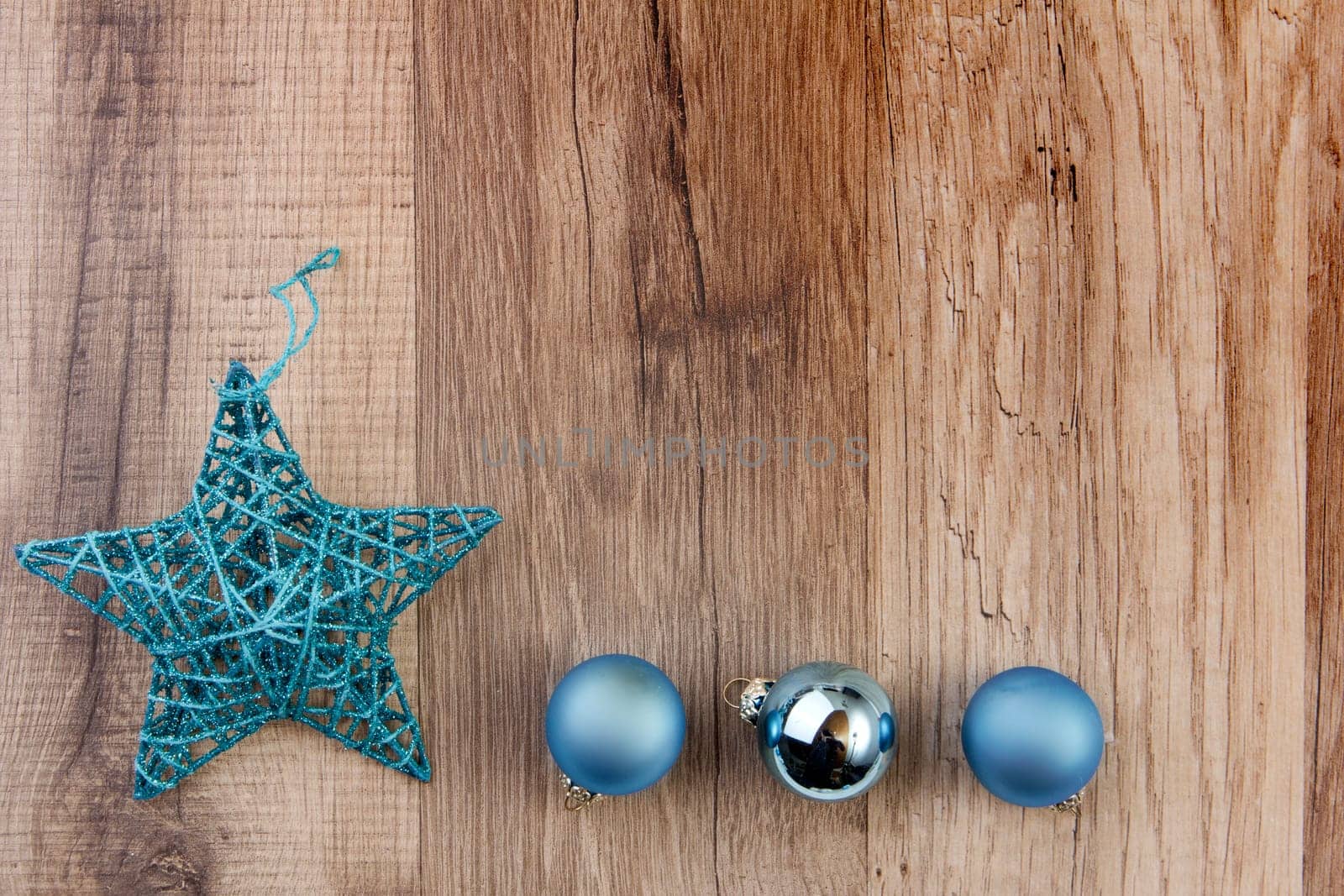 Christmas star and Christmas baubles turquoise on wooden background
