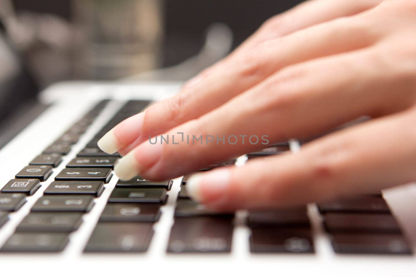 A woman's hands on a computer keyboard