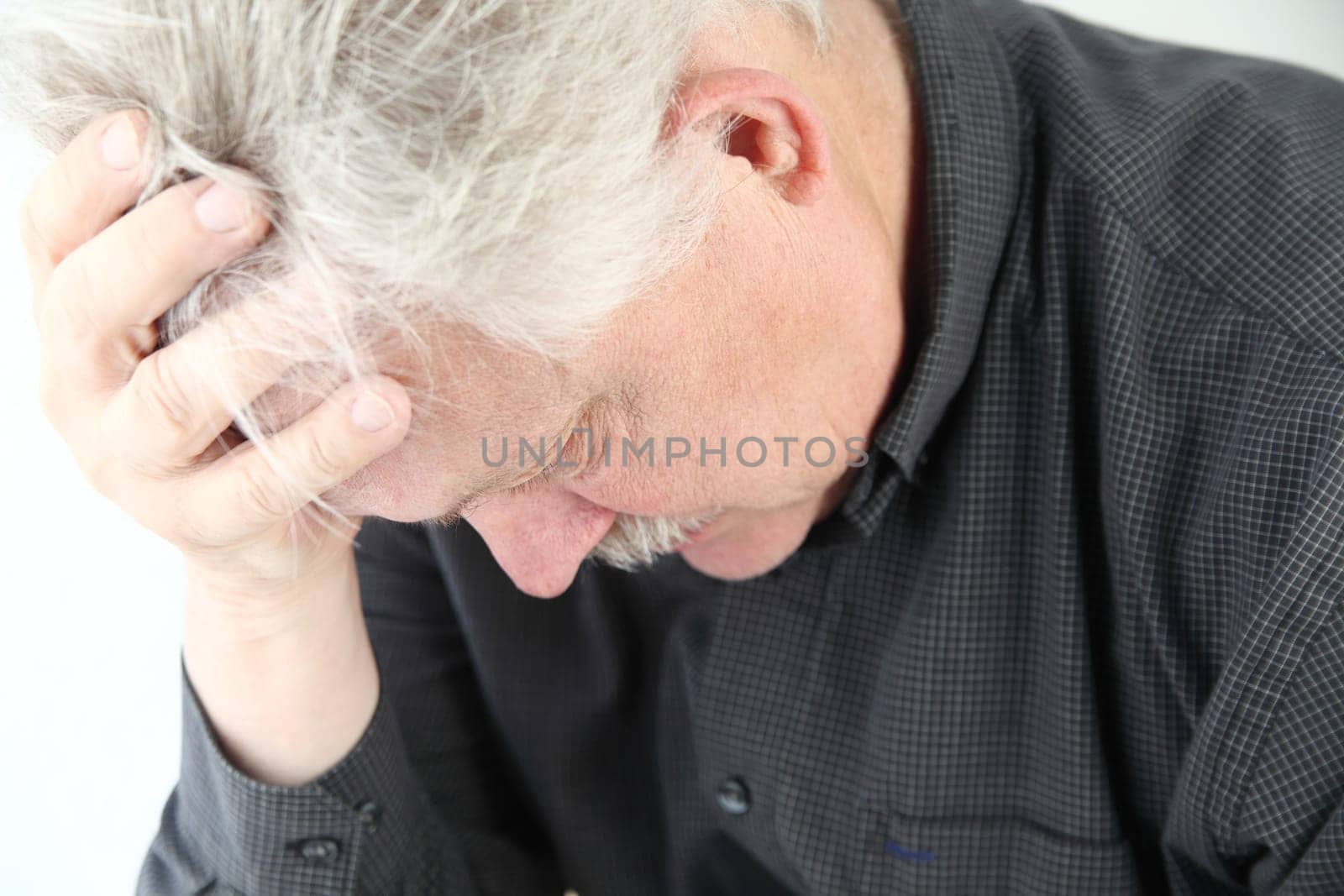 senior man bent over with grief or depression
