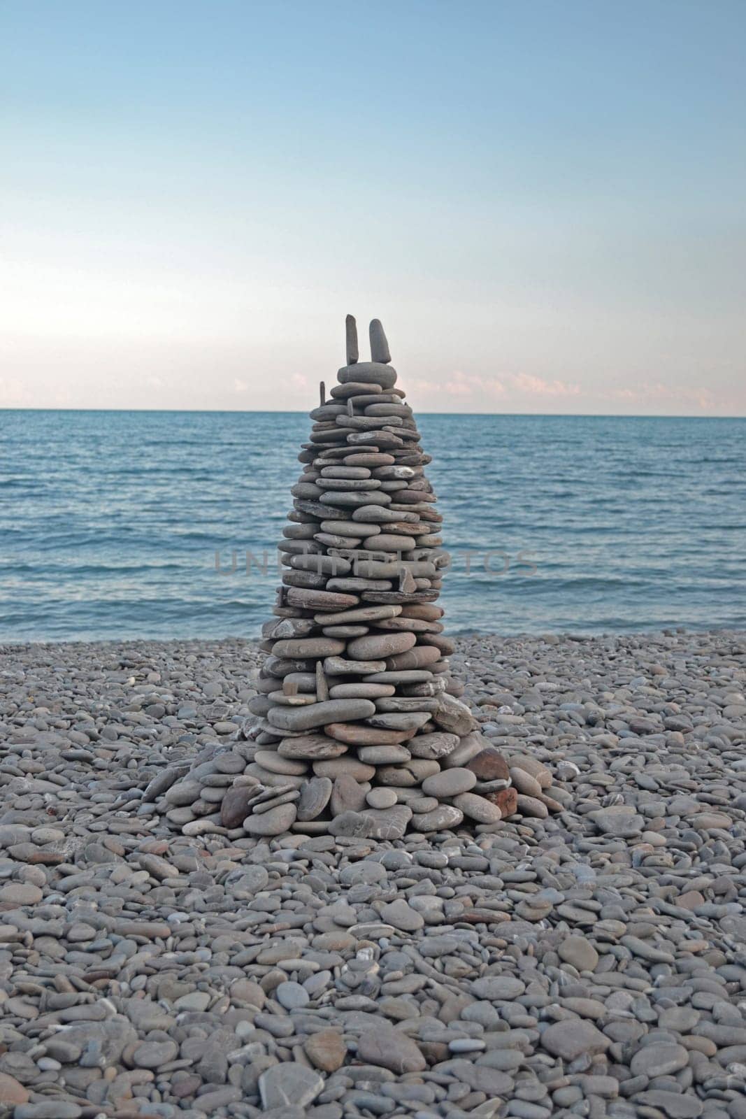 pyramid of stones on the beach during sunset