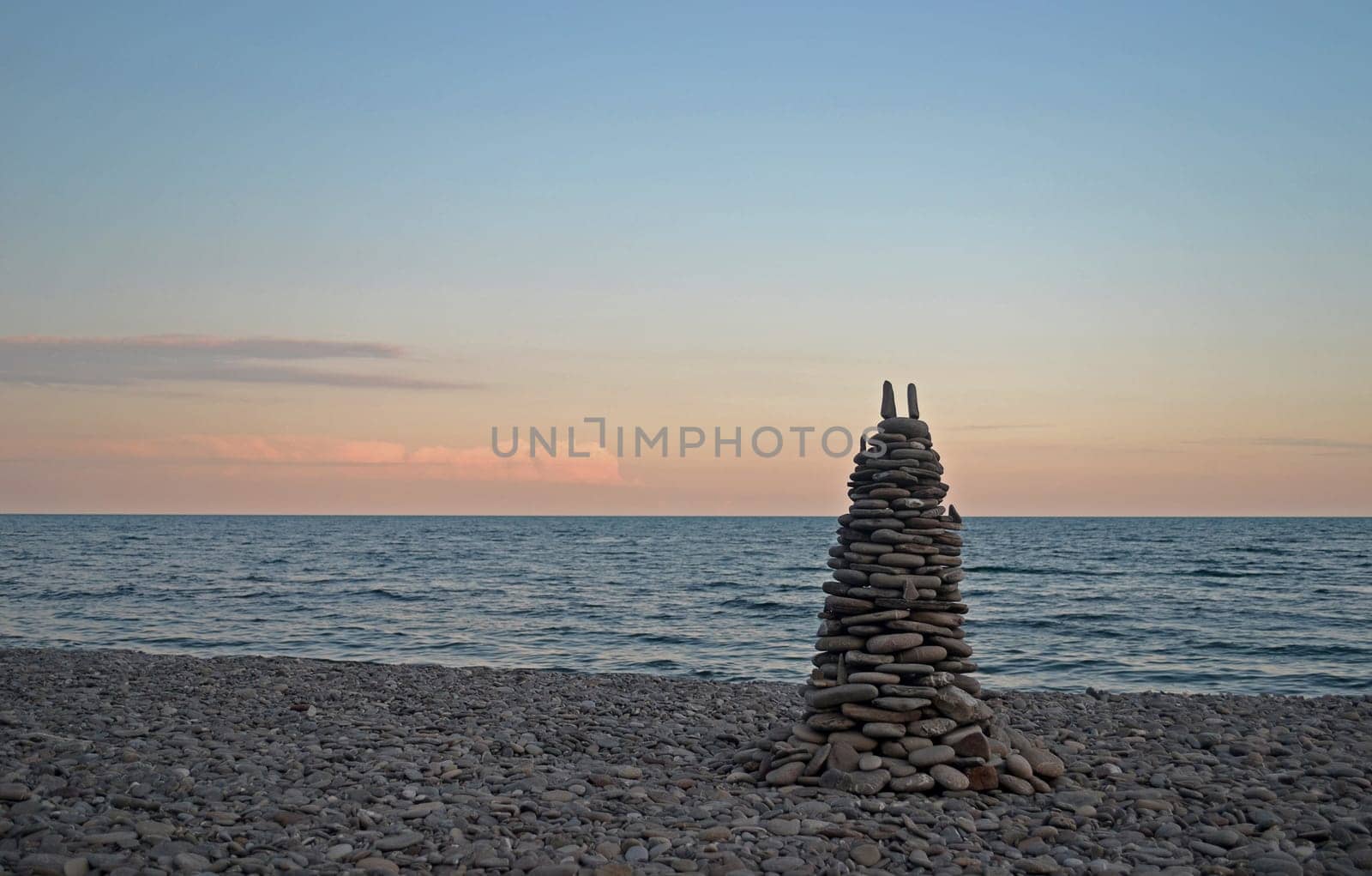 pyramid of stones on the beach during sunset