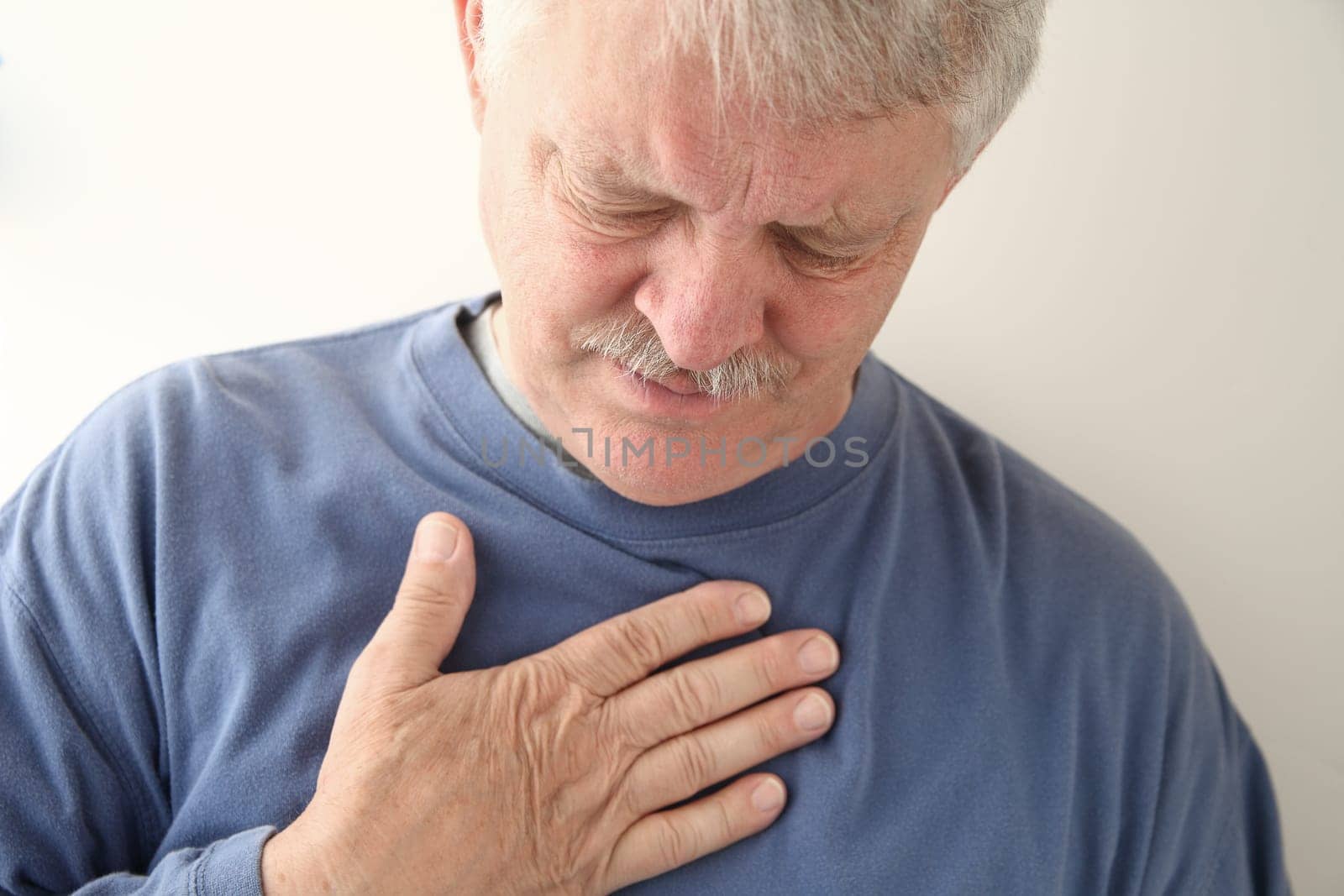 senior experiencing discomfort in his chest