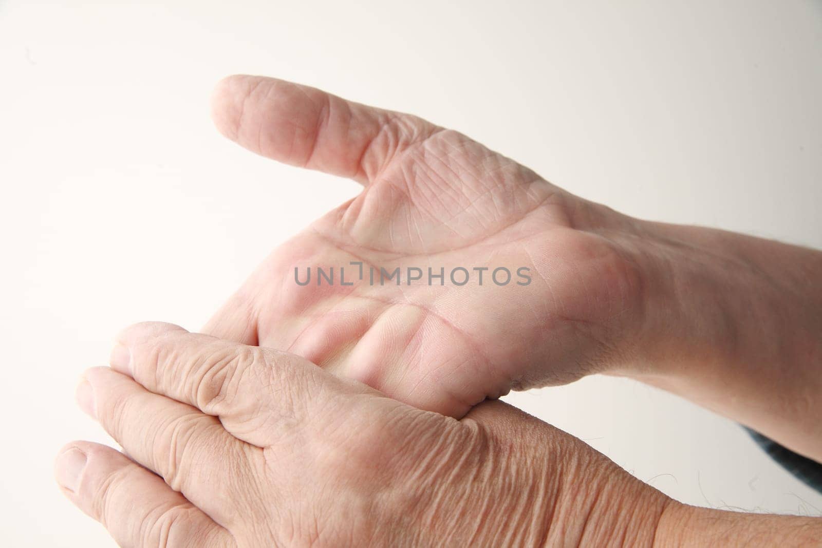 a man flexes one hand backward with the other