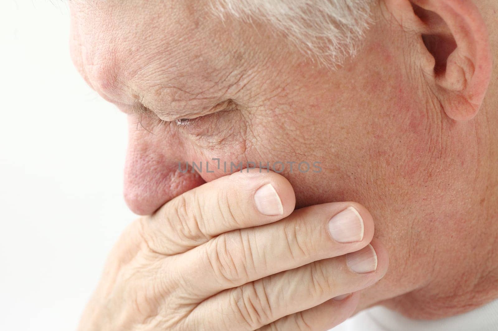 nauseated mature man holds hand up to mouth