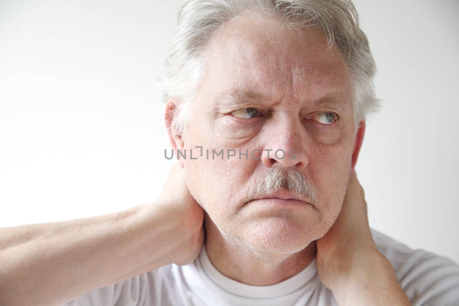 older man experiences soreness in his neck