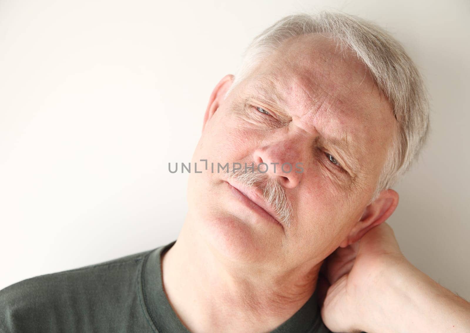 senior man has a painful stiff neck