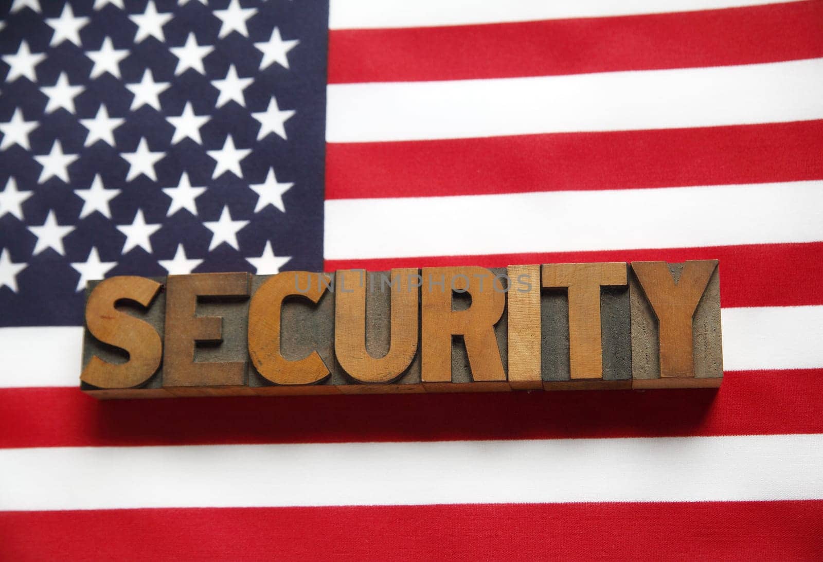 the word 'security' in old wood type on a USA flag