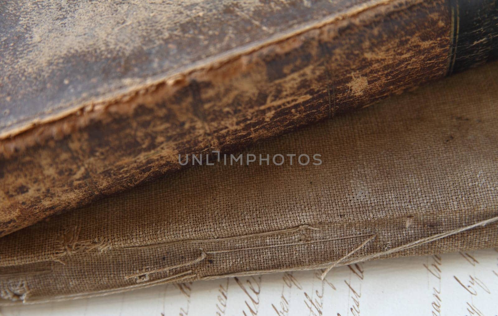 spine and covers of old, damaged books with a page of vintage script