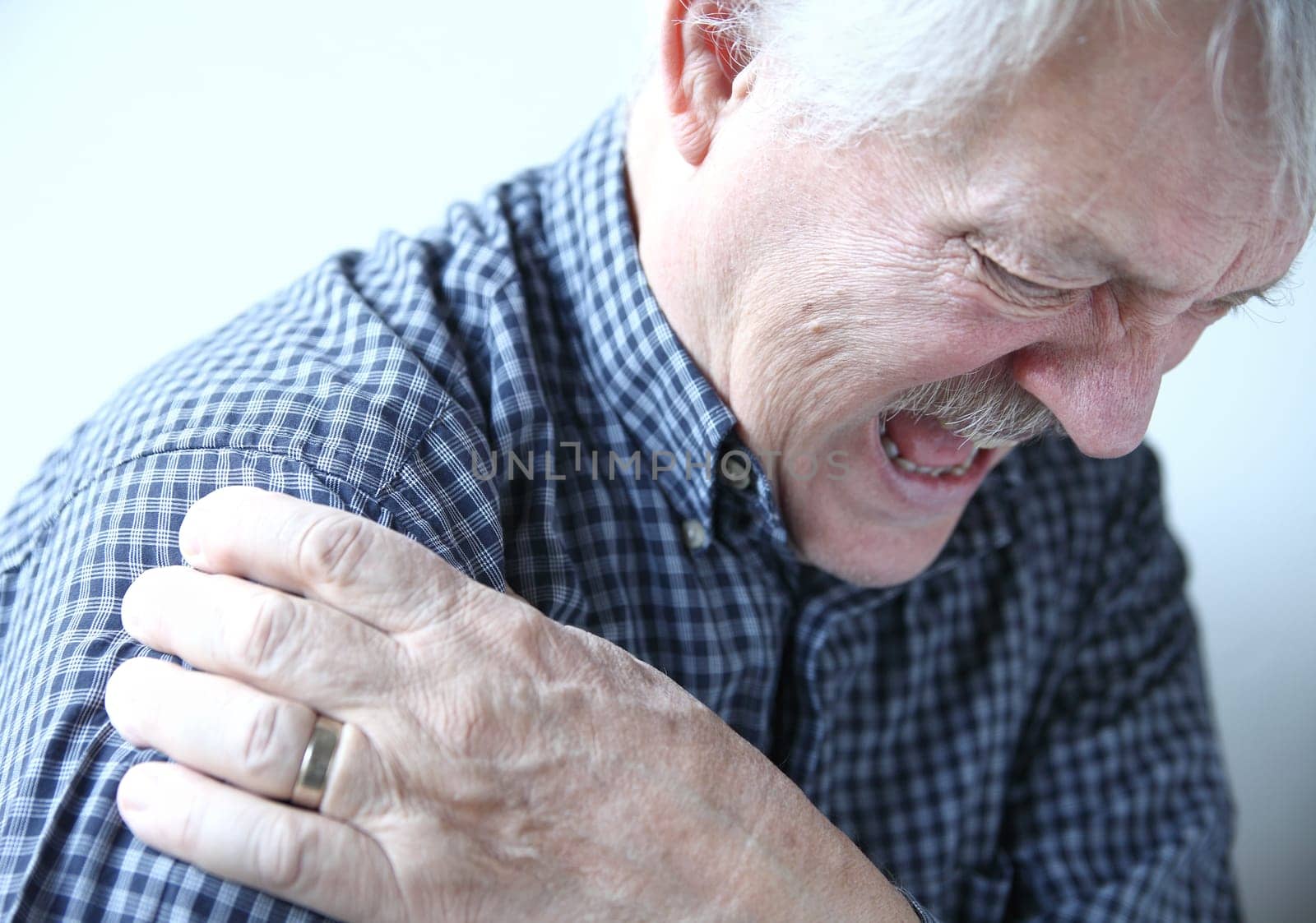 senior man suffering from pain in his shoulder