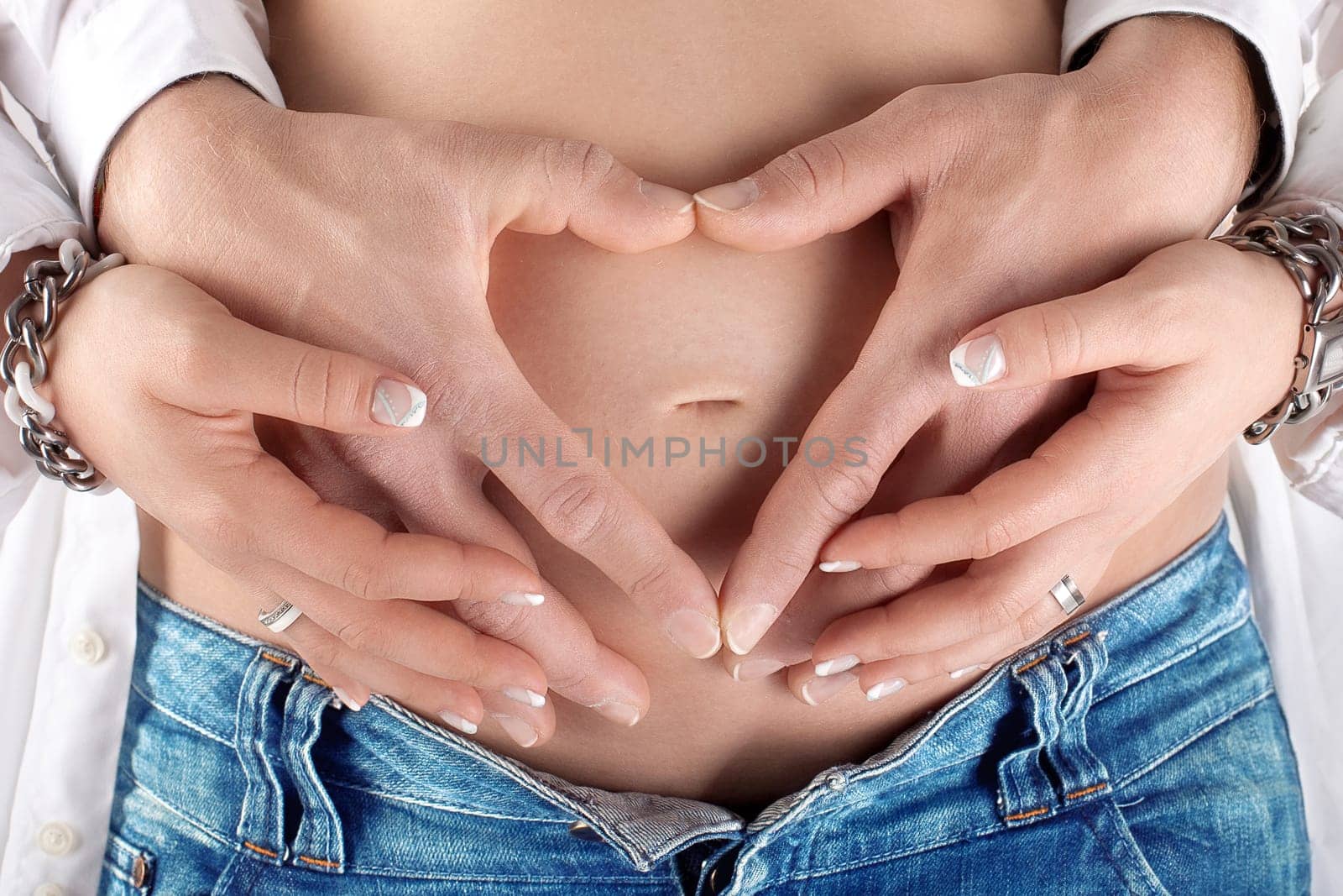 Parents-to-be form heart on baby belly