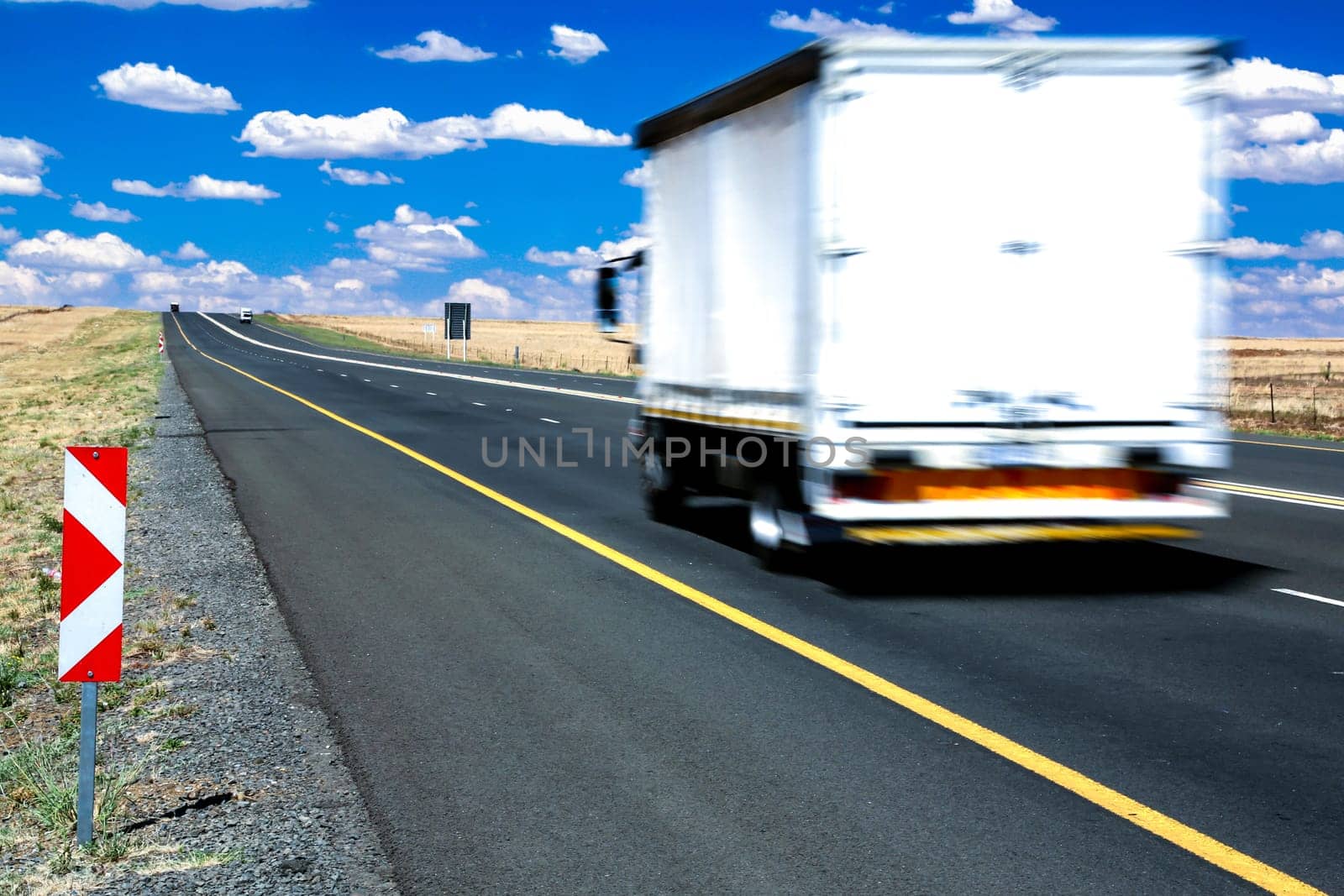 Big transporter truck travelling along the highway at speed