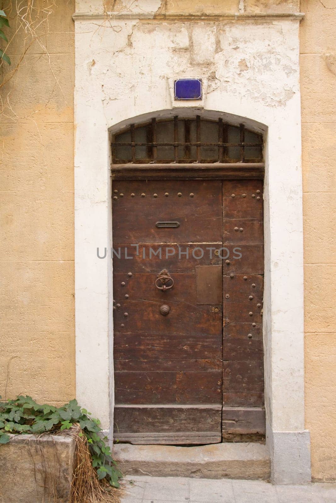 Old wooden entrance door to the house. Mediterranean architecture.